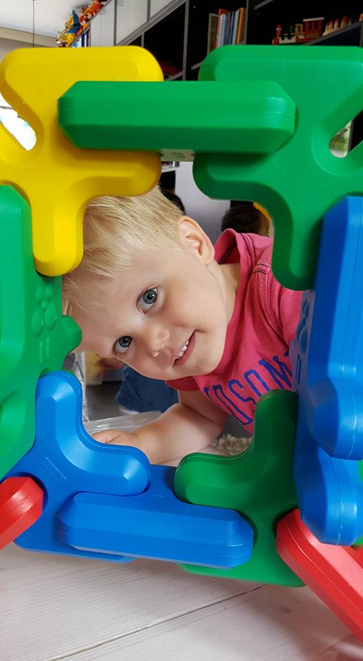 Kindje kijkt door fotolijstje gemaakt van bouwblokken